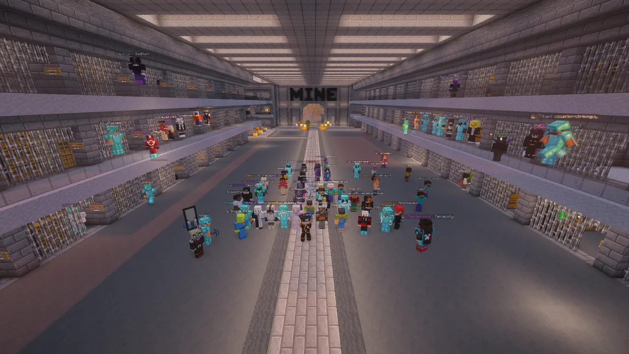 TitanMC players gathered between three levels of barred prison cells, with the mine entrance at the end of the hall